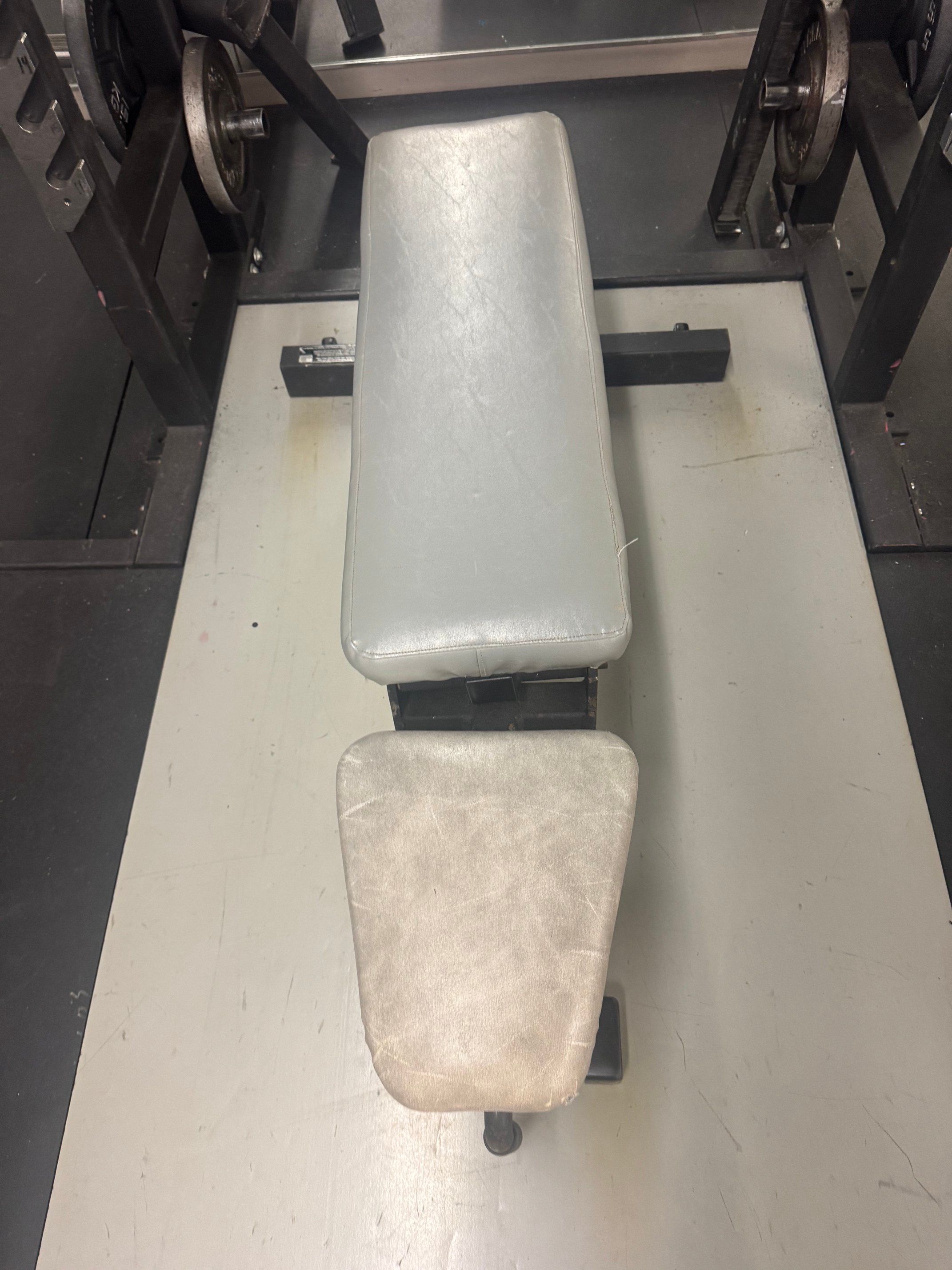 Weight room padded bench that adjust to 90 degrees.