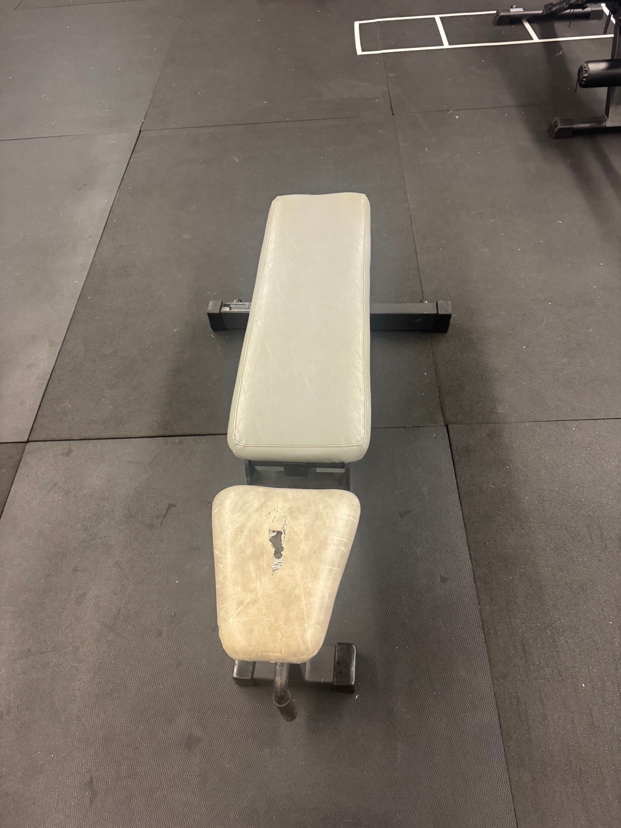 Weight room padded bench that adjust up to 90 degrees.