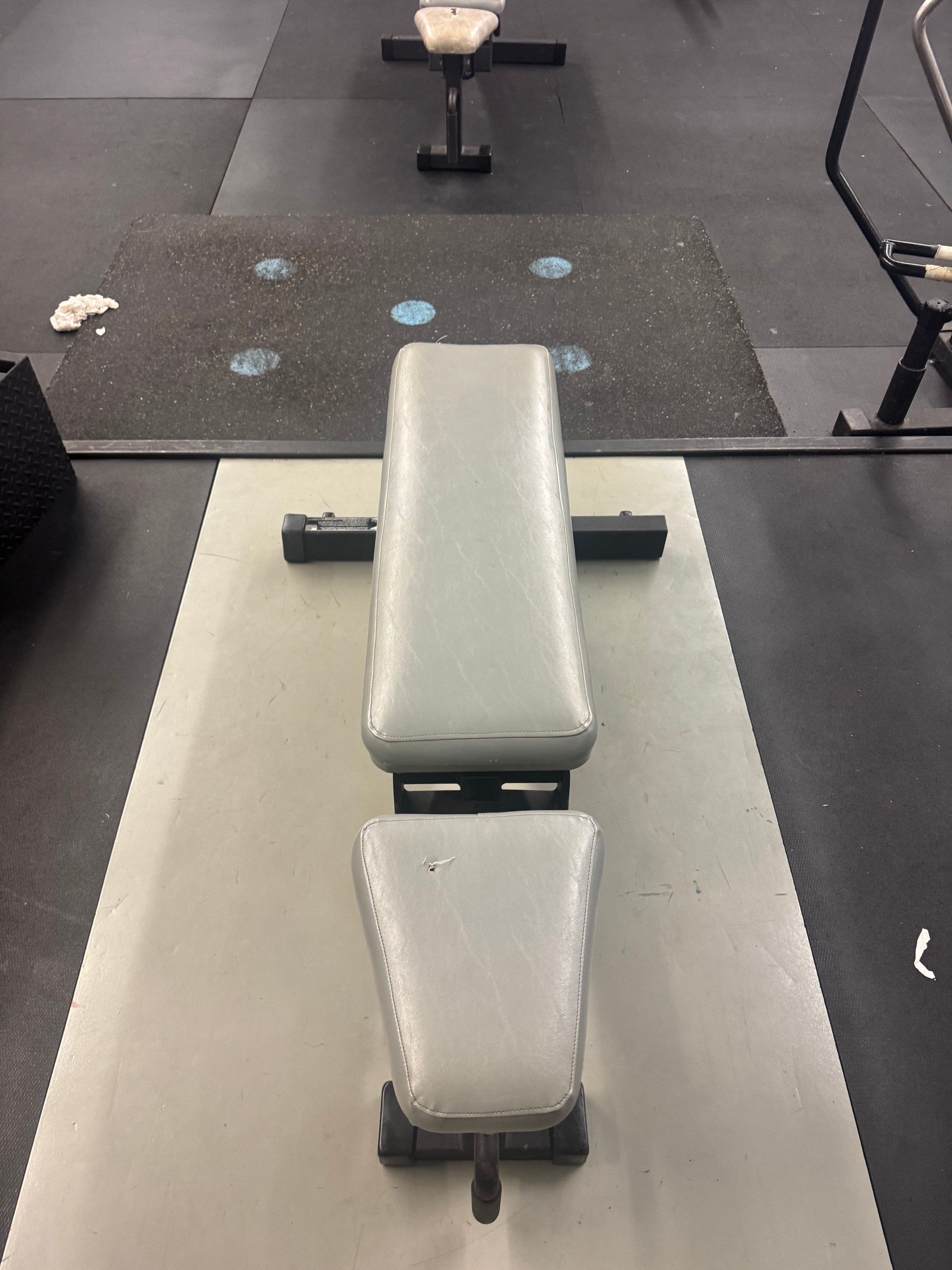 Weight room padded bench that adjust up to 90 degrees.