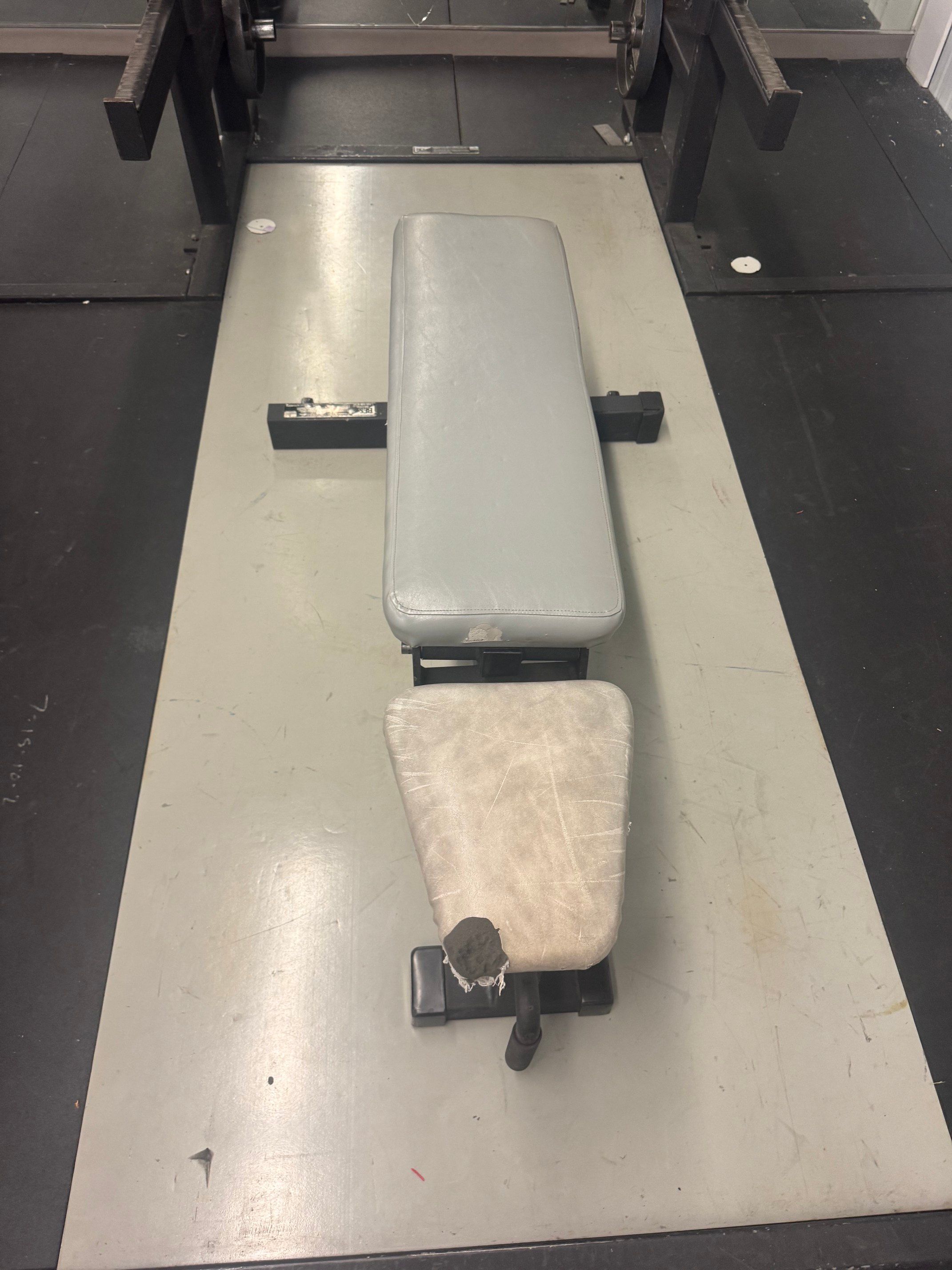 Weight room padded bench that adjust up to 90 degrees.